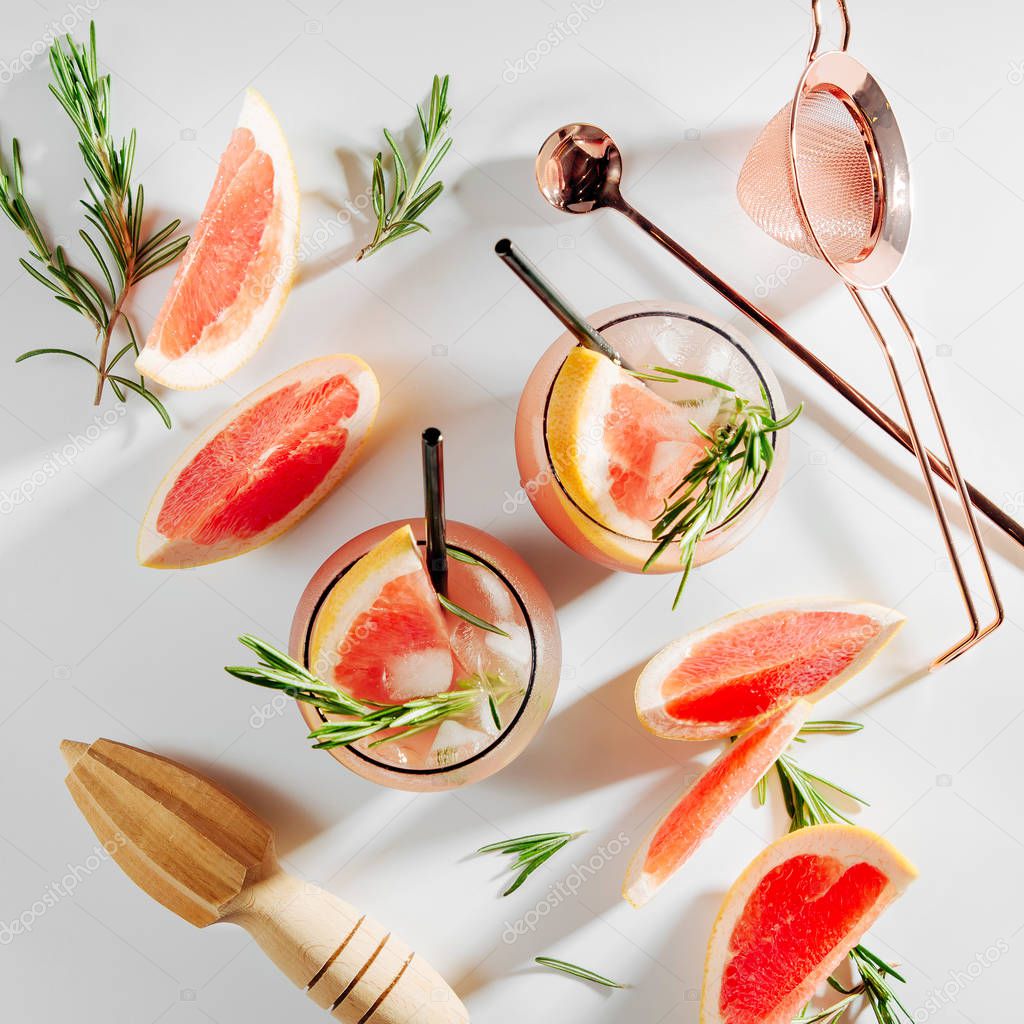 Two glass with Grapefruit and Rosemary cocktail. Summer drinks with fresh citrus and ice. 