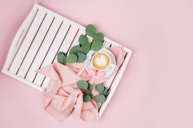 Bir fincan kahve Beyaz ahşap servis tepsisi ve okaliptüs dalı. Düz yatıyordu, en iyi görünümü