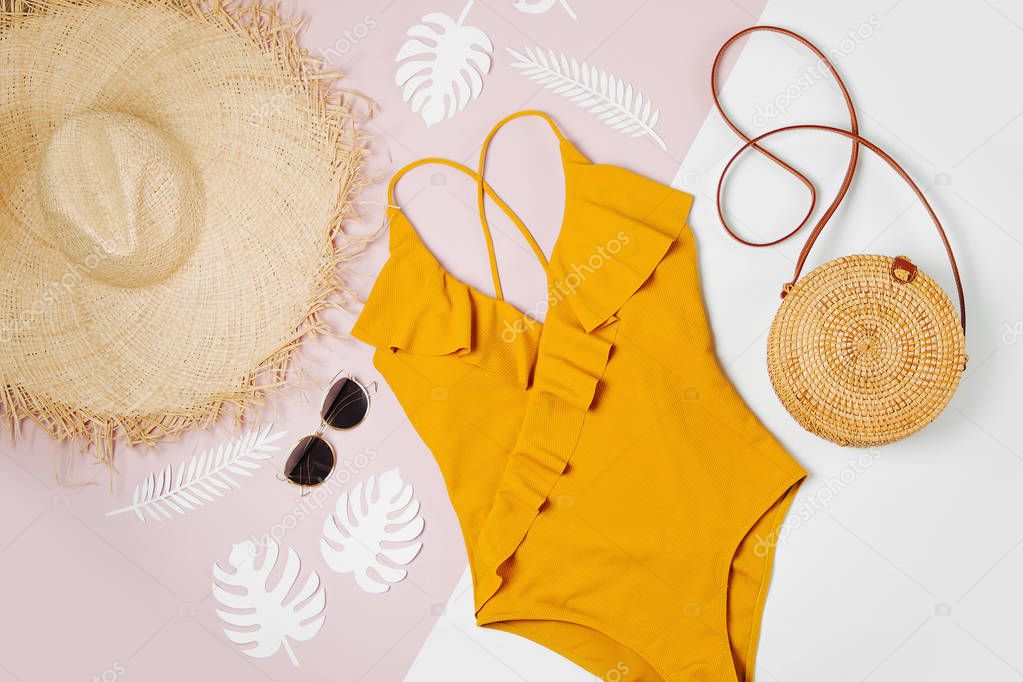 Fashion bamboo bag and sunglass, straw hat and swimsuit. Flat lay, top view. Summer Vacation concept.