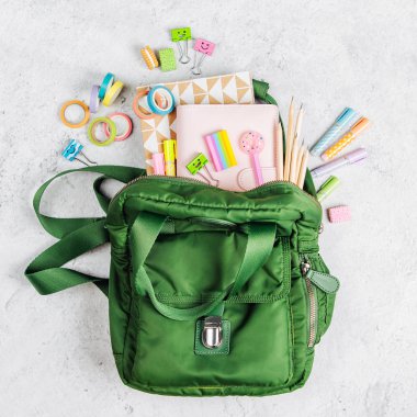 Sırt çantası, okul malzemeleri ve çalışma için kitaplar ile Düz yatıyordu