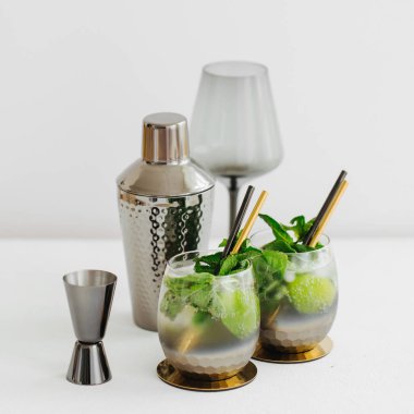 Beyaz masada kireç, nane ve buz ve bar aksesuarları ile kokteyl