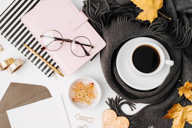 Boş kartlı dizüstü bilgisayar, atkı ve gözlükle sarılmış kahve fincanı ile çalışma alanı