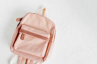 Beyaz arka planda şık soluk pembe sırt çantası