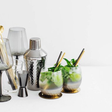 Beyaz masada kireç, nane ve buz ve bar aksesuarları ile kokteyl