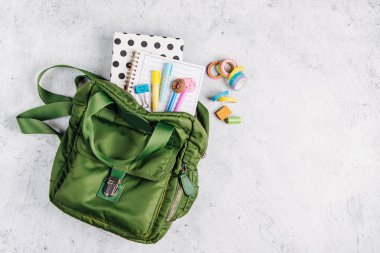 Sırt çantası, okul malzemeleri ve çalışma için kitaplar ile Düz yatıyordu