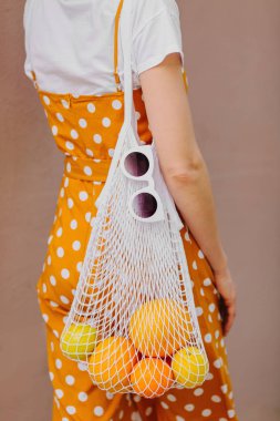 Meyve örgü çanta ile hasır şapka genç kadın