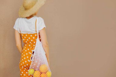 Meyve örgü çanta ile hasır şapka genç kadın