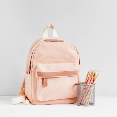 Beyaz arka planda şık soluk pembe sırt çantası