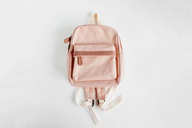 Beyaz arka planda şık soluk pembe sırt çantası