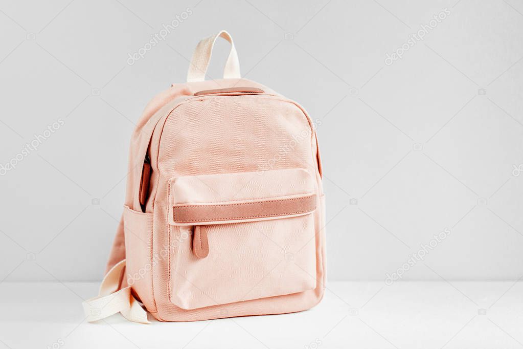 Stylish pale pink backpack on white background