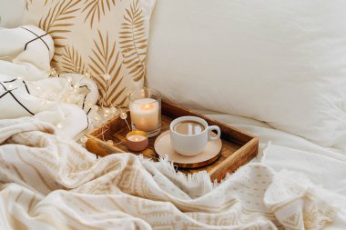 Yatakta kahve ve mumlar ahşap tepsi, Hygge kavramı
