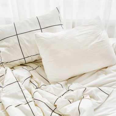 Çizgili battaniye ve yastıklar ile beyaz yatak çarşafları