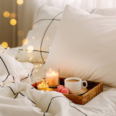 Yatakta kahve ve mumlar ahşap tepsi, Hygge kavramı