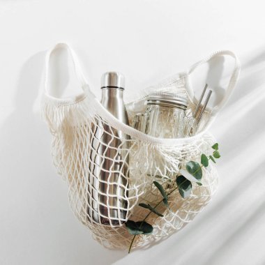 Yeniden kullanılabilir metal su şişesi, cam kavanoz ve saman ile pamuk net çanta