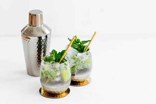 Cocktails with lime, mint and ice and bar accessories