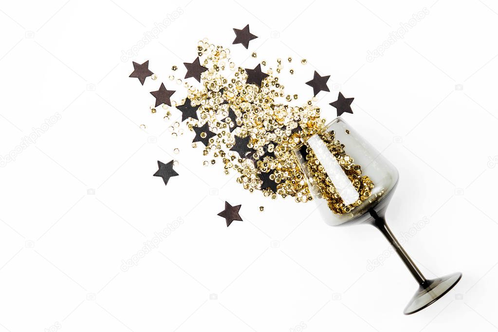 Black wine glasses with golden confetti and black stars on white background