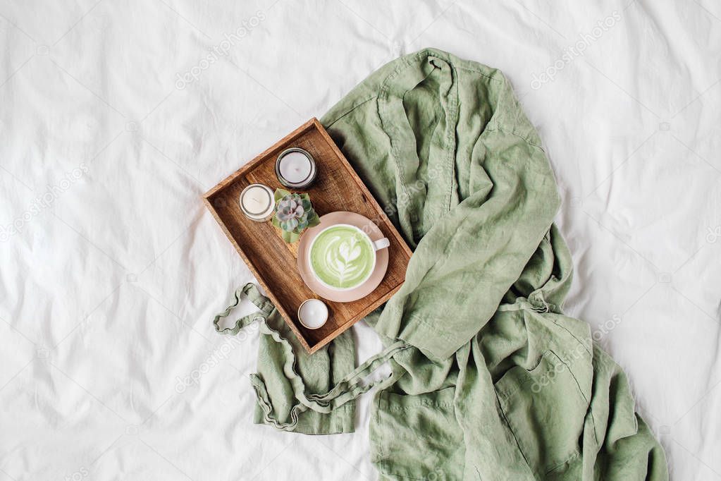 White bedding with dressing gown, tray of coffee and candles