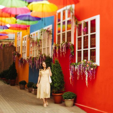 Sarı elbiseli seyahat turist esmer kadın şehrin parlak dekorasyon uy. Tilt-shift lens bulanıklığı