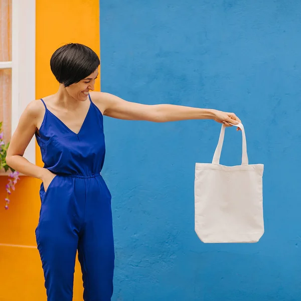 Mujer Sosteniendo Bolsa Lona Sobre Fondo Azul Brillante Ciudad Bolsa —  Fotos de Stock