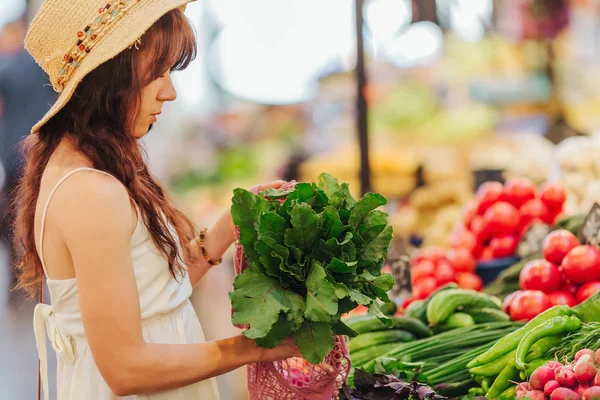 若い女性は 食品市場で綿の生産袋に果物や野菜を置きます 買い物に再利用可能なエコバッグ 廃棄物ゼロの概念 — ストック写真