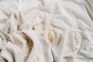 Sıcak ekoseli beyaz yatak. Kopyalama alanı olan rahat bir arkaplan. İskandinav tarzı. Düz yatış, üst görünüm