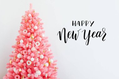 Pembe Noel ağacı ve noel süslemeleri beyaz ve altın rengi. Noel geçmişi. Mutlu Yıllar ve Xmas Noel kavramı.