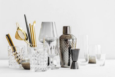 Bar aksesuarları ve kokteyl yapmak için aletler. Titretici, jigger, cam, kaşık ve diğer bar aletleri.