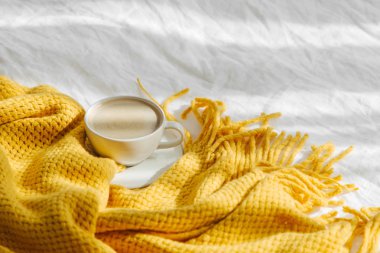 Sarı örme ekose ve kahve fincan ile Yatak . Kopyalama alanı ile rahat arka plan. Hygge kavramı.