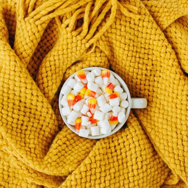 Sıcak ekose ile yatakta marshmallow ve şeker mısır ile Kahve. Sonbahar içeceği, yatakta kahvaltı. Hygge kavramı.