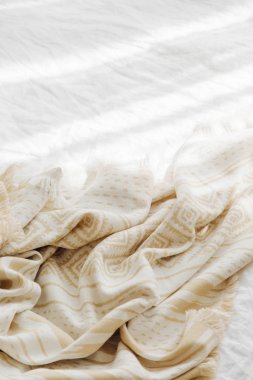 Sıcak ekoseli beyaz yatak. Kopyalama alanı olan rahat bir arkaplan. İskandinav tarzı. Düz yatış, üst görünüm