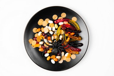 Renkli şekerli siyah tabak. Trick or Treat, Cadılar Bayramı için kavram. Düz döşeme, üst görünüm