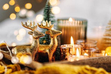 Sıcak ekose ile ahşap tepsi üzerinde mumlar ve noel süslemeleri yanan. Kış rahat tarzı. Hygge kavramı. 