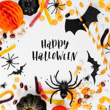 Renkli şeker, yarasalar, örümcekler, kabaklar ve beyaz arka plan dekorasyon ile Halloween tatil çerçevesi. Düz yatıyordu. Yukarıdan görüntüle
