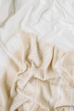 Sıcak ekoseli beyaz yatak. Kopyalama alanı olan rahat bir arkaplan. İskandinav tarzı. Düz yatış, üst görünüm