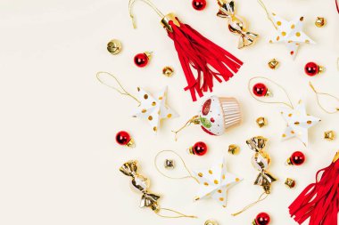 Noel süslemeleri, şeker, yıldız, pastel arka plan üzerinde altın ve kırmızı renklerde püskül. Tatil ve kutlama. Düz döşeme, üst görünüm