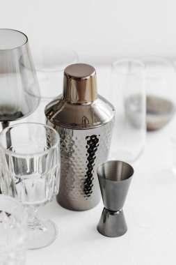 Bar aksesuarları ve kokteyl yapmak için aletler. Titretici, jigger, cam, kaşık ve diğer bar aletleri.