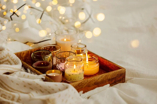 在床上用温暖的格子在木托盘上燃烧蜡烛 斯堪的纳维亚风格 海格概念 — 图库照片