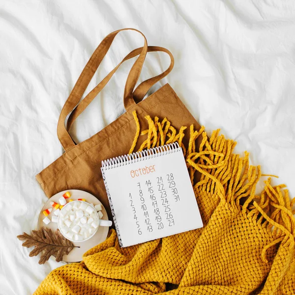 Cotton eco bag with cup of coffee and notebook  on bed. Autumn concept.