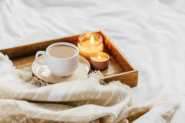 咖啡和蜡烛托盘与温暖的格子在白色床上用品 早餐在床上 斯堪的纳维亚风格 顶视图 — 图库照片
