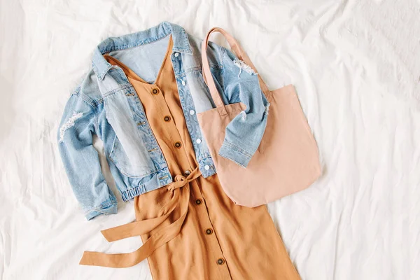 Chaqueta Jean Azul Vestido Beige Con Bolso Mano Cama Blanca — Foto de Stock