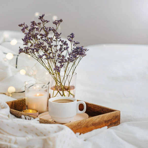 咖啡和蜡烛的木托盘 床上有鲜花 白色床上用品 带条纹毯子和枕头 早餐在床上 海格概念 — 图库照片