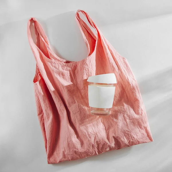 Pink cloth shopping bag and  reusable coffee mug. Zero waste, plastic free concept.