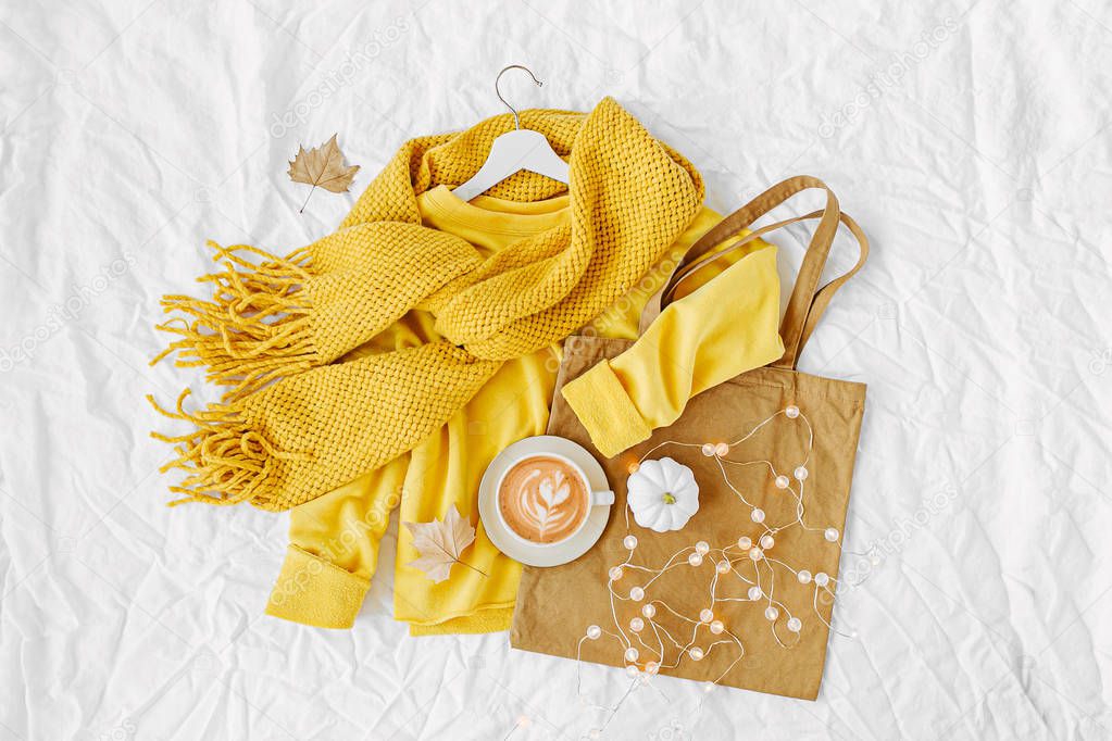 Yellow sweater with knitted scarf,  tote bag and cocoa drink. Autumn mood. Fashion clothes collage on white background. Top view flat lay.