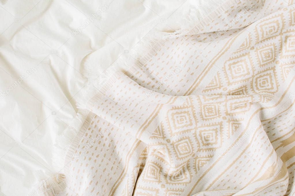 White bedding with warm plaid. Cozy background with copy space. Scandinavian style.  Flat lay, top view