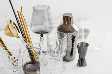 Bar aksesuarları ve kokteyl yapmak için aletler. Titretici, jigger, cam, kaşık ve diğer bar aletleri.