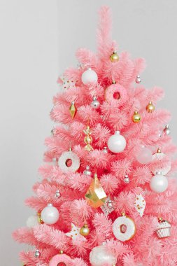 Pembe Noel ağacı ve noel süslemeleri beyaz ve altın rengi. Noel geçmişi. Mutlu Yıllar ve Xmas Noel kavramı.