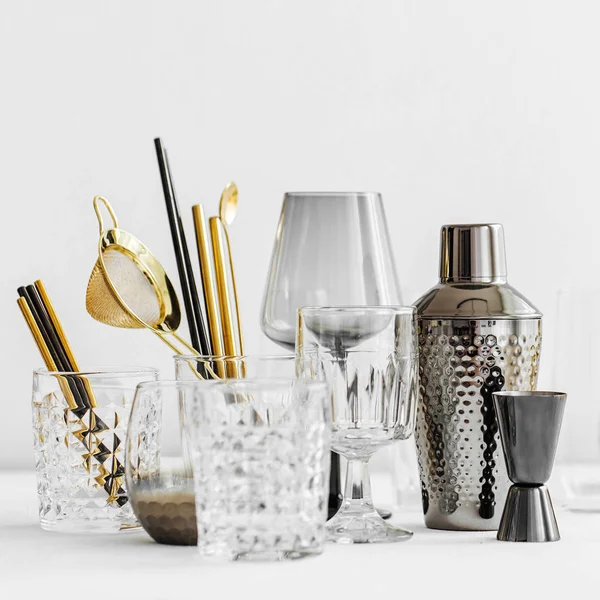 Bar aksesuarları ve kokteyl yapmak için aletler. Titretici, jigger, cam, kaşık ve diğer bar aletleri.