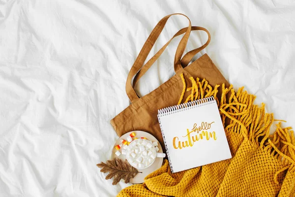 Cotton eco bag with cup of coffee and notebook  on bed. Autumn concept.