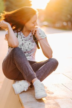 Sırt çantası ile seyahat turist kadın gün batımında sokaklarda yürüyor.