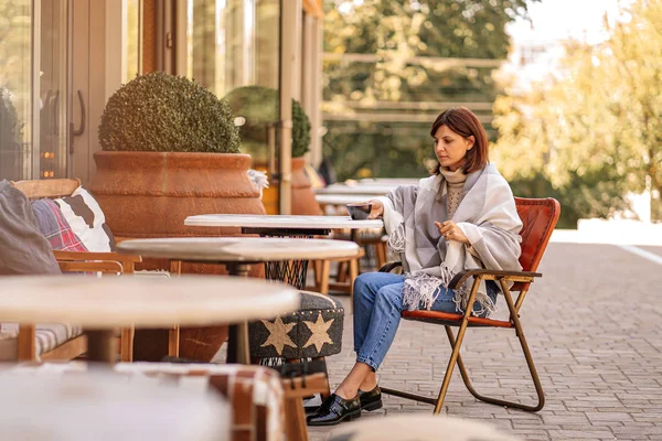 아름다운 소녀는 담요에 테라스에 카페에 휴식과 커피를 마시는 — 스톡 사진